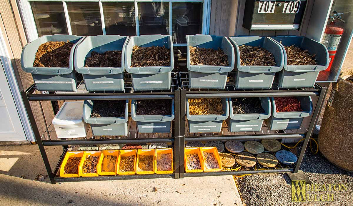 Bins of mulch and stone samples on display outside our office