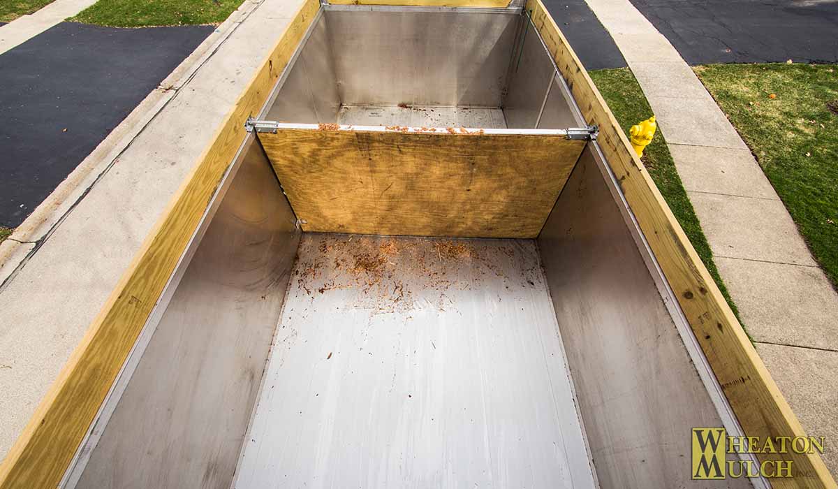 The plywood divider that keeps two products apart in the truck bed